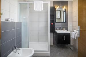 a bathroom with a sink and a toilet and a mirror at Urban Premium Apartments in Poreč