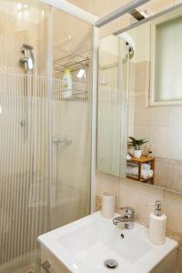 een badkamer met een wastafel en een douche met een spiegel bij Pásti Centrál apartment. in Debrecen