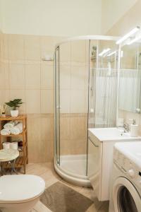 een badkamer met een douche, een toilet en een wastafel bij Pásti Centrál apartment. in Debrecen