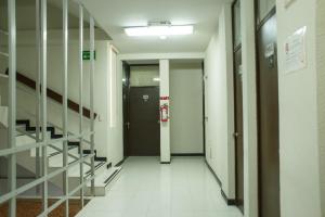 un couloir d'un hôpital avec une porte et des escaliers dans l'établissement Fiesta Versalles, à Monterrey