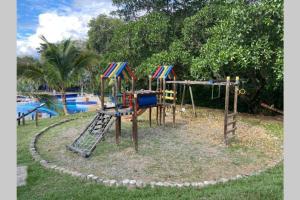 a playground with a slide and a swing set in a park at Apartasol El Encanto in San Jerónimo