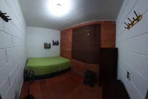 a small room with a green bed in the corner at Apartasol El Encanto in San Jerónimo +32 photos