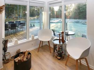 OddeにあるHoliday Home Jægerparkenの窓付きの客室で、白い椅子2脚とテーブル