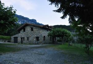 un antiguo edificio de piedra con una montaña en el fondo en Casa Rural Don Fernando en Los Molinos