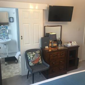 a room with a desk and a chair and a mirror at Spurwing Guest House in Wareham +11 photos