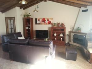 a living room with a leather couch and a fireplace at Casa Rural Sierra San Mamede in La Codosera