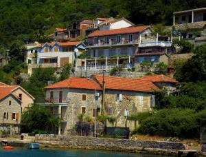 a group of houses on a hill next to the water at Apartments Okuka in Tivat