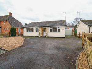 a house with a driveway in front of it at Giggling Goose Cottage in Woodhall Spa