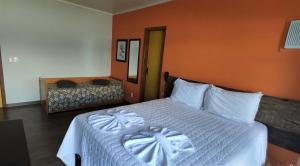 a hotel room with a bed, chair, and nightstand at Pousada Ecomar in Florianópolis