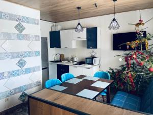 a kitchen with a table and blue chairs in a room at DanRock in Yablunytsya