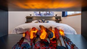 a bedroom with a bed with a fireplace next to it at Sport Hotel Alpina in Madesimo