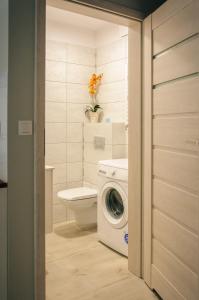 een badkamer met een wasmachine en een toilet bij NADMORSKI-DOM Pobierowo Summer-house in Pobierowo