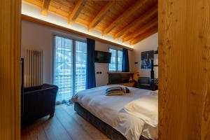 a bedroom with a large bed and two windows at Sport Hotel Alpina in Madesimo
