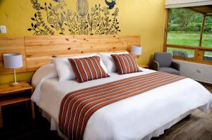 a bedroom with a large white bed and a window at Killawasi Lodge in Yanque