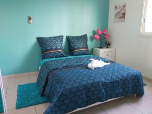 a blue bedroom with a bed with a stuffed animal on it at Appartement face à la marina du marin martinique in Le Marin