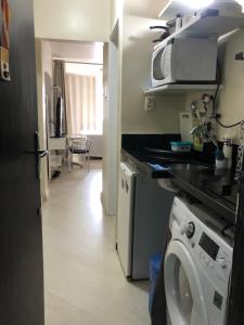 cocina con lavadora y microondas en Slow Coast Apartment Paim x Frei, en São Paulo