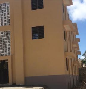 ein Gebäude mit drei Fenstern an der Seite in der Unterkunft Brink Breeze Guest Rooms & Apartments in Mombasa