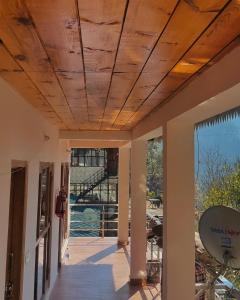 a room with a wooden ceiling with a view of a building at Babutaal Resort in Chakrāta