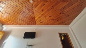 a room with a wooden ceiling and a tv on a wall at Babutaal Resort in Chakrāta