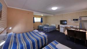 a hotel room with two beds and a television at Binalong Motel in Goondiwindi