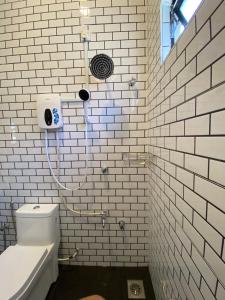 e bagno piastrellato bianco con doccia e servizi igienici. di Bangi Utara Villa a Kajang Altre 14 foto