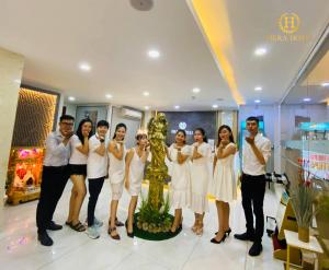 a group of people standing next to a christmas tree at Hera Hotel Airport in Ho Chi Minh City