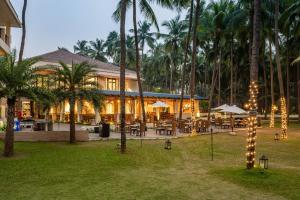 达曼Silver Waves Resort & Spa - Daman的棕榈树、桌子和灯