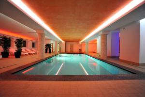 ein großes Schwimmbecken in einem Gebäude mit Beleuchtung in der Unterkunft Hotel Derby in Bormio