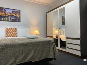 a bedroom with a bed and a large mirror at Quarto Luxo Silver in Anápolis