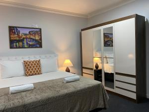 a bedroom with a large bed and a mirror at Quarto Luxo Silver in Anápolis
