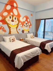 a bedroom with two beds and a mural of monkeys at Mo Dou Homestay in Taitung City