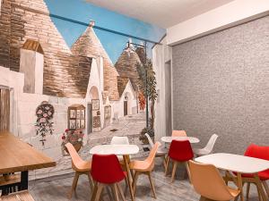 a restaurant with tables and chairs in front of a wall at Mo Dou Homestay in Taitung City