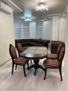 einen Tisch und Stühle in einem Zimmer mit Sofa in der Unterkunft апартаменти люкс роксолани 16 in Truskawez