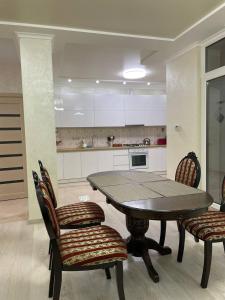 ein Esszimmer mit einem Tisch und Stühlen in einer Küche in der Unterkunft апартаменти люкс роксолани 16 in Truskawez