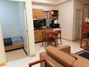 a living room with a couch and a kitchen at Timurbay Seafront Seaview & Poolview Suite with Wi-Fi in Kuantan