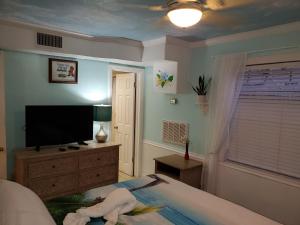 a bedroom with a bed and a flat screen tv at The Monterey Beach Resort in St Pete Beach