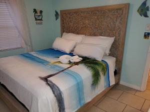 a bedroom with a bed with a bird on a branch at The Monterey Beach Resort in St. Pete Beach