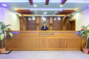 a man standing behind a reception desk in a hotel lobby at Siddhartha Hotel Grand City in Birtamode