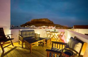 a patio with chairs and a table on a balcony at Lindos Boutique - Adults Only in Lindos