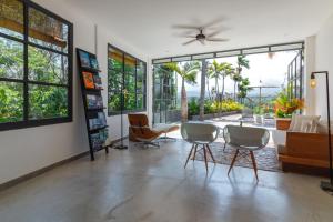 a living room with chairs and a table and windows at Villa Lempuyangdream in Karangasem