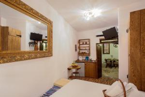 a bedroom with a mirror on the wall and a table at Lindos Boutique - Adults Only in Líndos