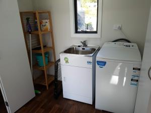a small kitchen with a sink and a refrigerator at Stony Creek, 3 bedroom home, Franz Josef in Franz Josef