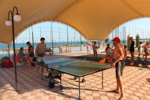 a group of people playing ping pong in a tent at Отель Анна Мария in Kurortne