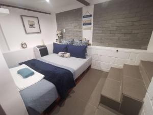 a bedroom with a large bed with blue pillows at The nest in East London