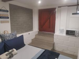 a room with a red door and stairs with a microwave at The nest in East London