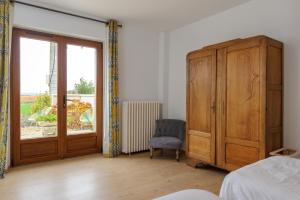 a bedroom with a wooden cabinet and a window at La Ferme de Wary in Brimont