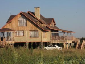 a house with a car parked in front of it at Sangare Gardens in Mweiga