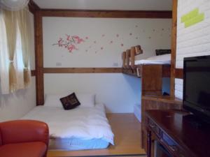 a room with two bunk beds and a tv at Share B&B in Puli