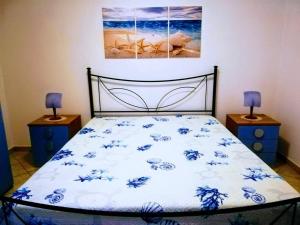 a bedroom with a bed with blue flowers on it at Casa Isulidda in San Vito lo Capo