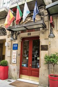 un bâtiment avec des drapeaux suspendus au-dessus de la porte d'un restaurant dans l'établissement Hotel Náutico, à Vigo